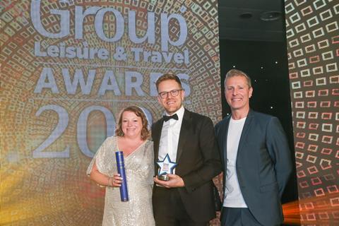 Monika Zywczak from Group Line presents the GLT award to Josh Behn of Disney Tickets, alongside host Paul Zerdin.