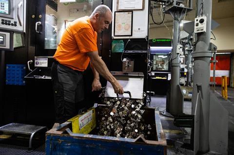 Worker at the Royal Mint Experience sorting through coins